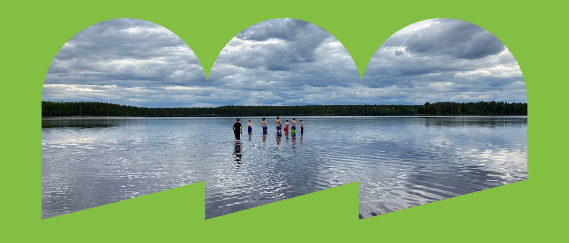 Vihreiden kehysten sisällä valokuva, jossa nuorten porukka seisoo vedessä. Horisontti on tasainen, musta viiva, joka erottaa sinisen ja pilvisen taivaan sitä heijastavasta vedestä.