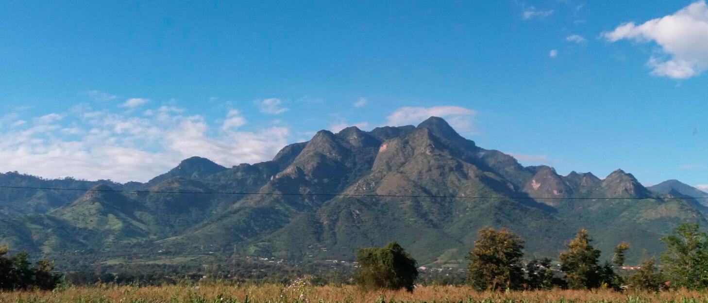 Uluguru-vuoristoa Morogorossa, Tansaniassa, taustalla sininen taivas, etualalla kellastunutta heinää.