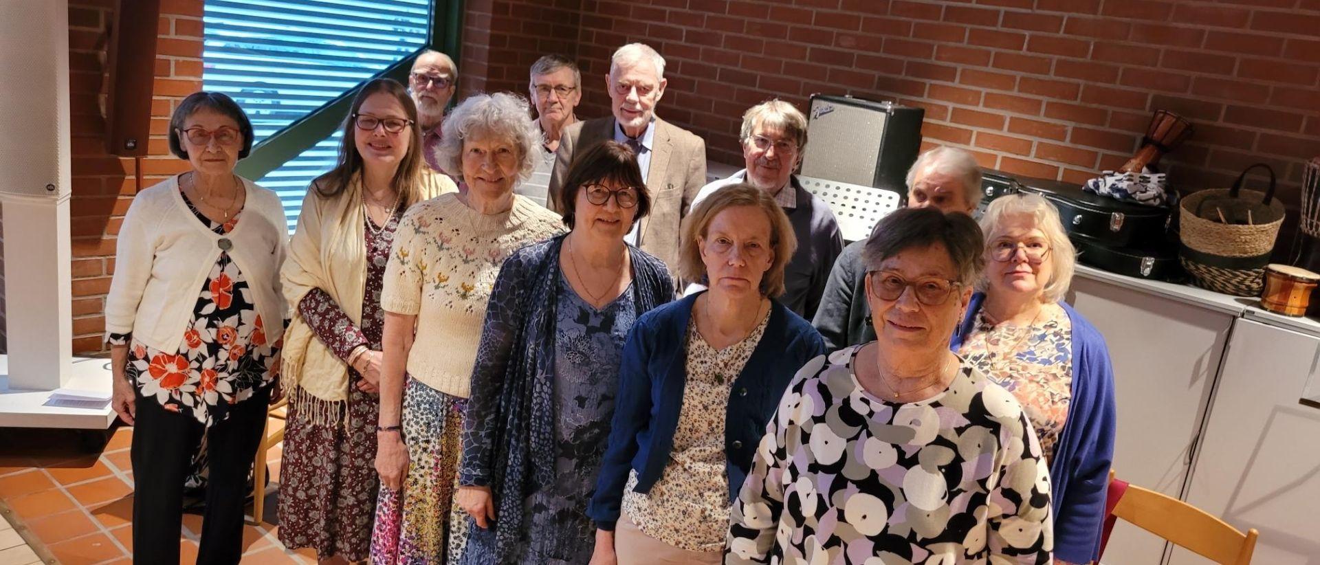 Matteus Kyrkokör står uppställda i Matteuskyrkan tillsammans med dirigent Sirkku-Liisa Niemi