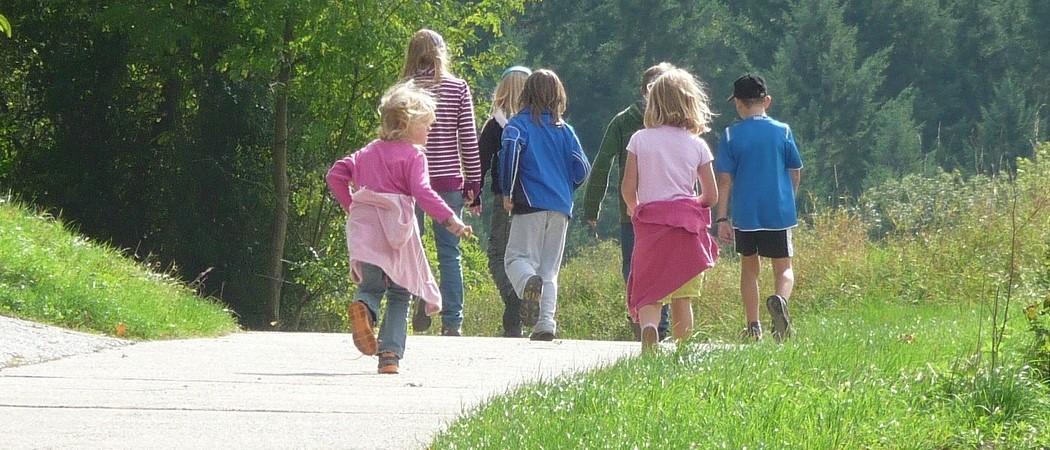 neljä lasta kävelee tietä pitkin