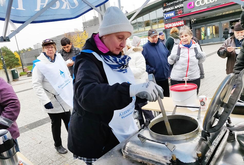 Vapaaehtoinen Aino Raittinen annostelee rokkaa Vuosaaren srk:n köyhyystapahtuma Mosaiikkitorilla