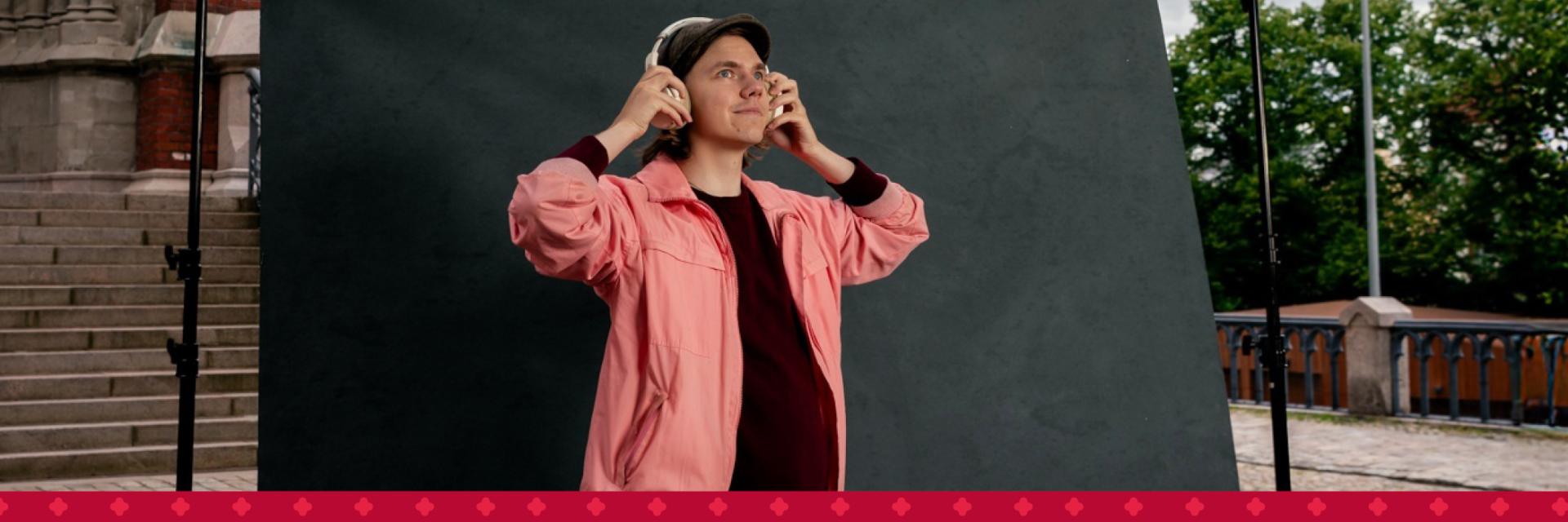 En ung man som lyssnar på musik i hörlurar