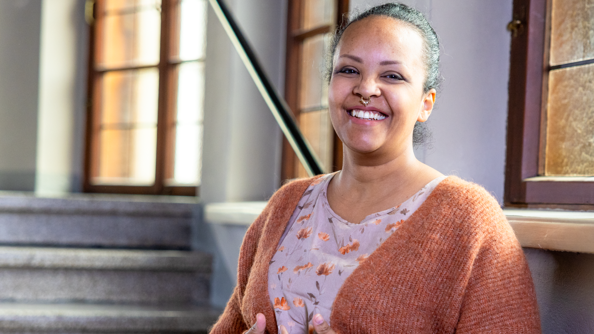 En kvinna i en kyrka, hon ler.