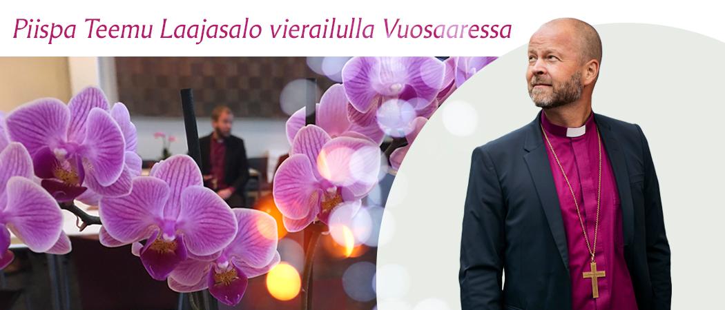 Kuva piispa Teemu Laajasalosta. Taustalla kukkia ja Vuosaaren kirkon seurakuntasali.