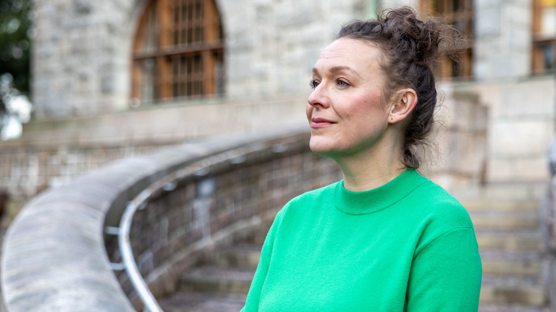 En kvinna med fundersam min, utanför kyrkan i Berghäll.