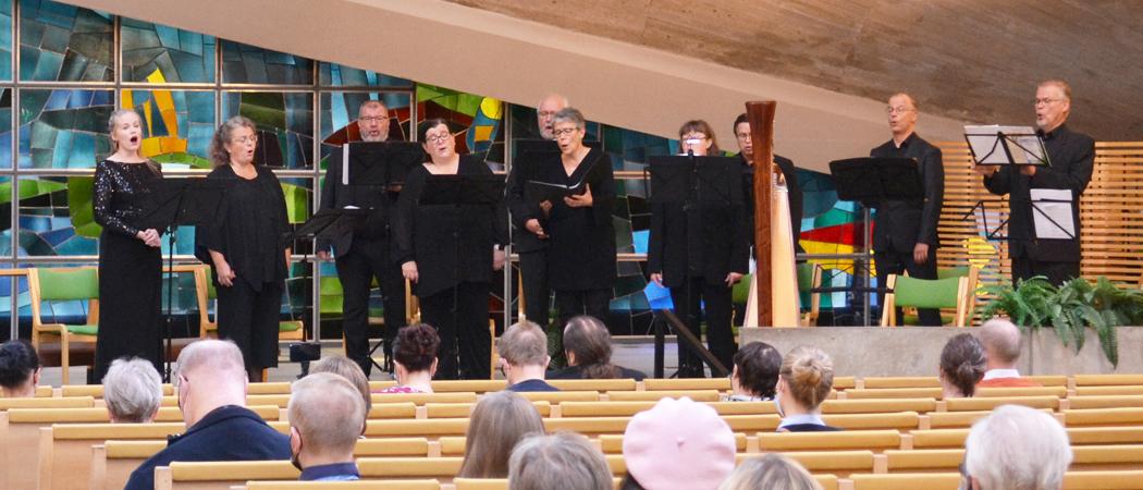 Vokaaliyhtye CantoNovo esiintymässä Kannelmäen kirkossa ja yleisöä.