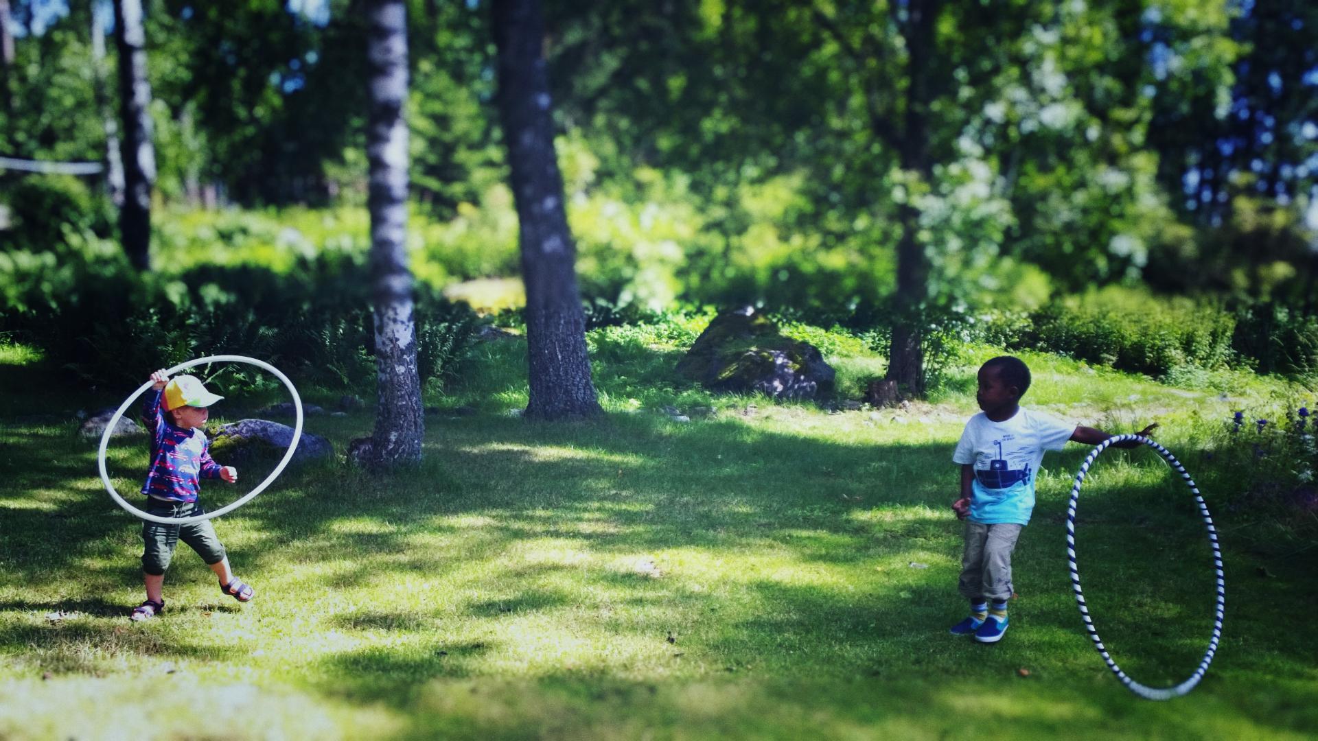 Barn som leker med ringar på en gräsmatta.