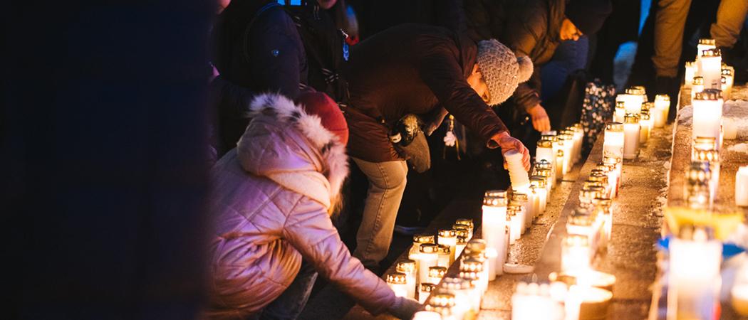 Ihmiset laskevat kynttilöitä Tuomikirkon portaille