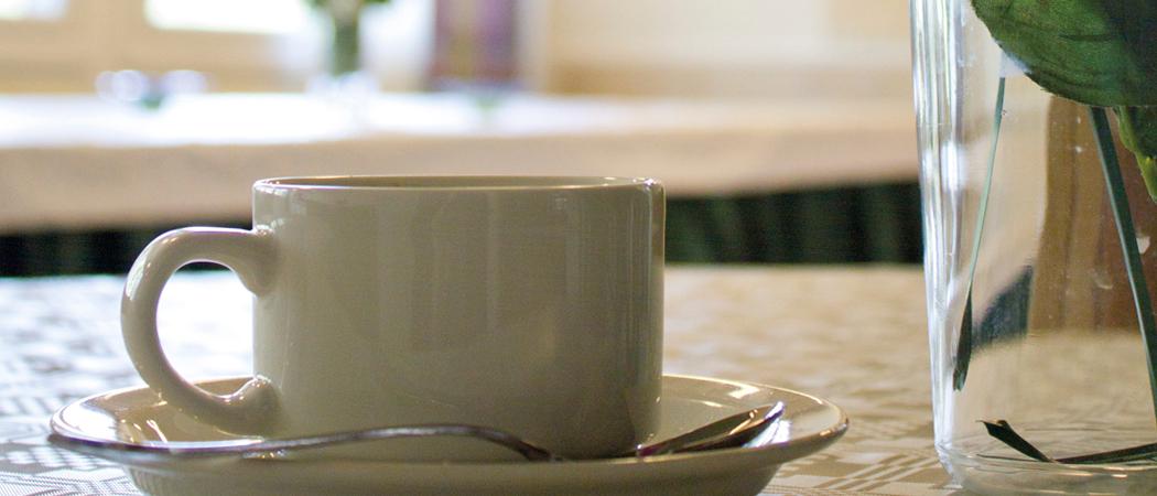 Arabian valkoinen kahvikuppi seurakuntasalin pöydällä.