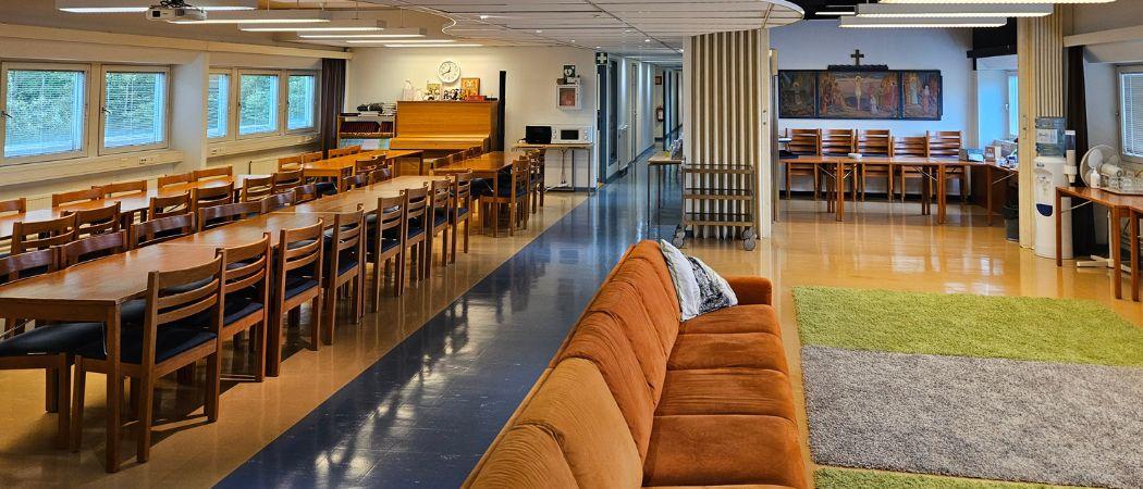 Klanun aukiolla pitkiä sohvia ja pitkiä pöytiä.