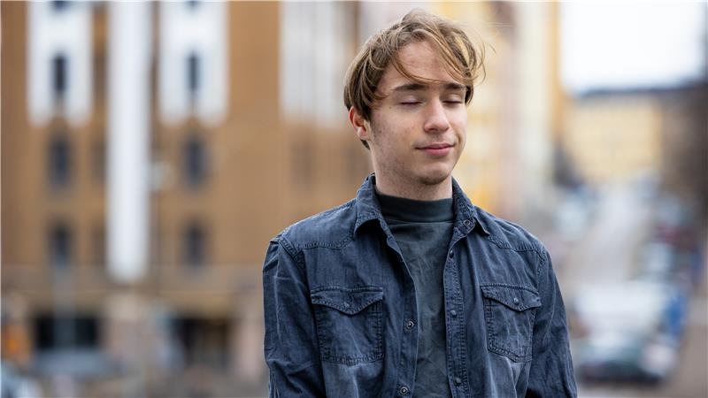 En ung man med slutna ögon. Kanske lyssnar han till något?